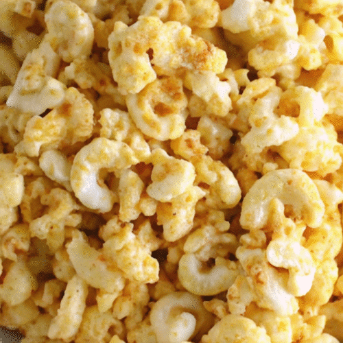 Bowl of deviled egg macaroni salad snack with crunchy texture and creamy seasoning, served on a blue napkin