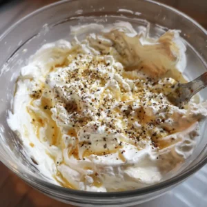 Bowl of creamy high-protein egg salad mixture with Greek yogurt, Dijon mustard, and black pepper.